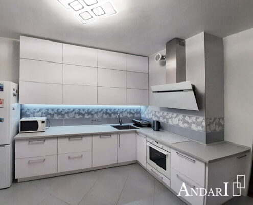 Белая угловая кухня до потолка с фасадами из пластика Fenix